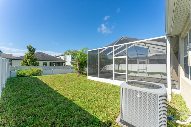 view of yard featuring a lanai, central AC, and a patio