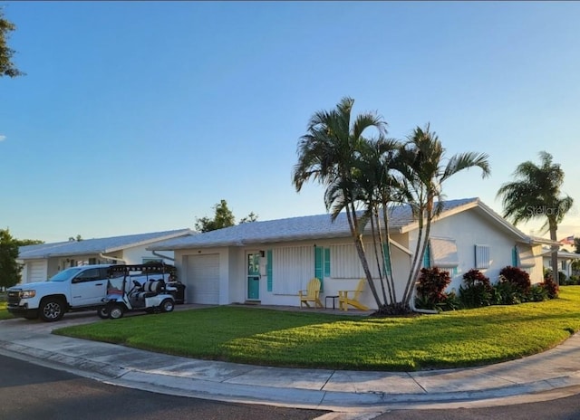 single story home featuring a garage and a front lawn