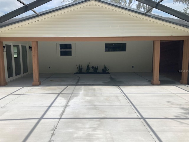 rear view of house with glass enclosure and a patio area