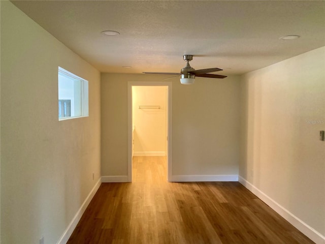 empty room featuring a textured ceiling, ceiling fan, and hardwood / wood-style flooring