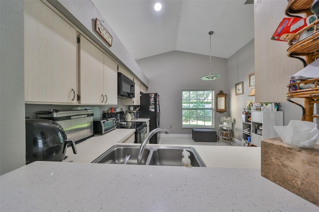 kitchen featuring black appliances, hanging light fixtures, sink, and vaulted ceiling