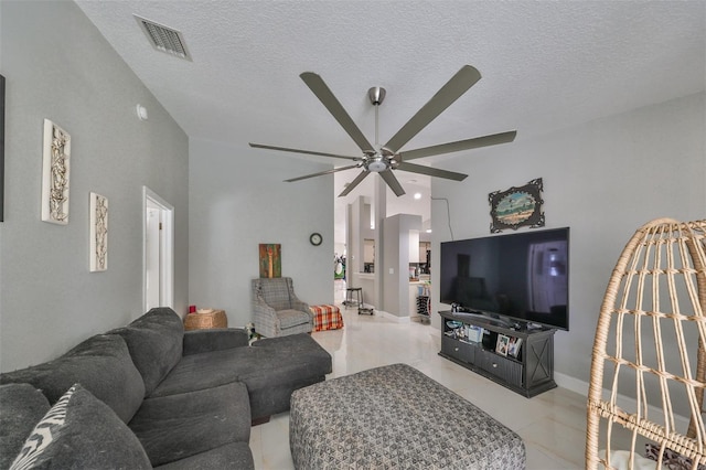 living room with a textured ceiling and ceiling fan