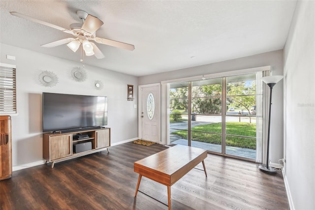 living room featuring a textured ceiling, ceiling fan, and dark hardwood / wood-style flooring