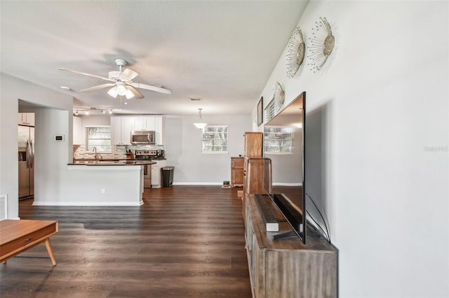 living room with ceiling fan and dark hardwood / wood-style flooring