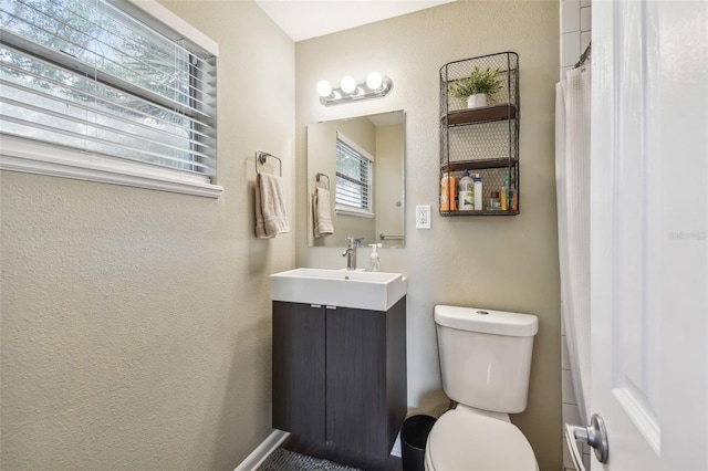 bathroom with a wealth of natural light, vanity, a shower with shower curtain, and toilet