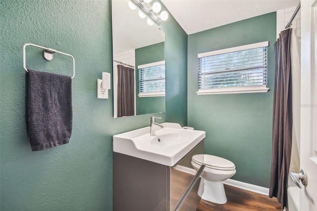 bathroom with toilet, hardwood / wood-style floors, and vanity