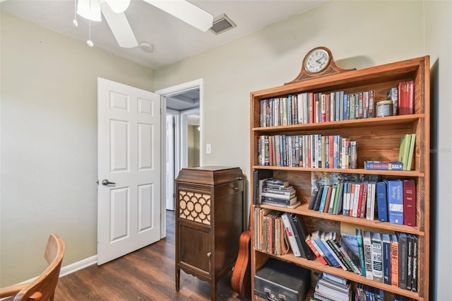 living area with dark wood-type flooring and ceiling fan