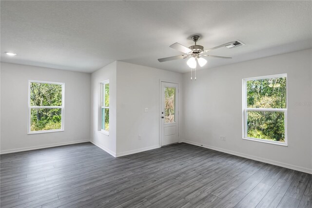 unfurnished room featuring a textured ceiling, ceiling fan, and dark hardwood / wood-style flooring