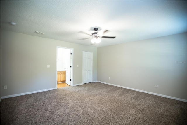 spare room featuring a textured ceiling, ceiling fan, and carpet