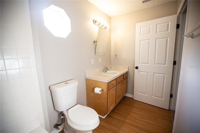 bathroom featuring a shower, toilet, hardwood / wood-style flooring, and vanity