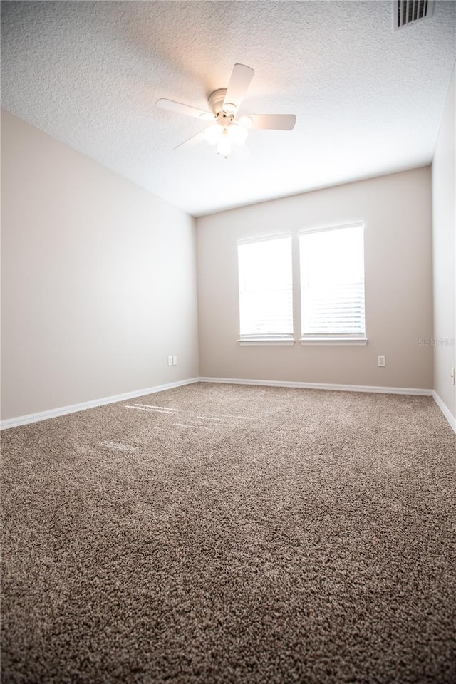 carpeted empty room featuring a textured ceiling and ceiling fan