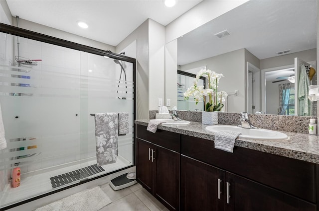 bathroom featuring tile patterned floors, ceiling fan, a shower with door, and vanity