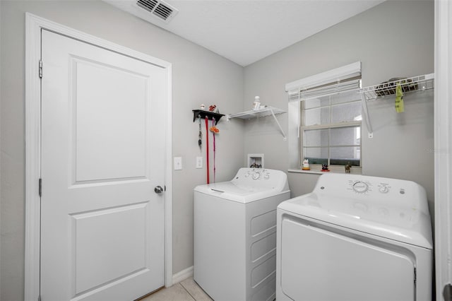 washroom featuring light tile patterned floors and washer and clothes dryer