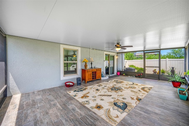 unfurnished sunroom with ceiling fan