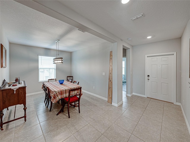 tiled dining space featuring a textured ceiling