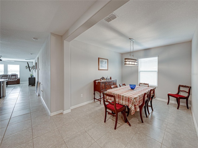 dining area with a textured ceiling and light tile patterned floors