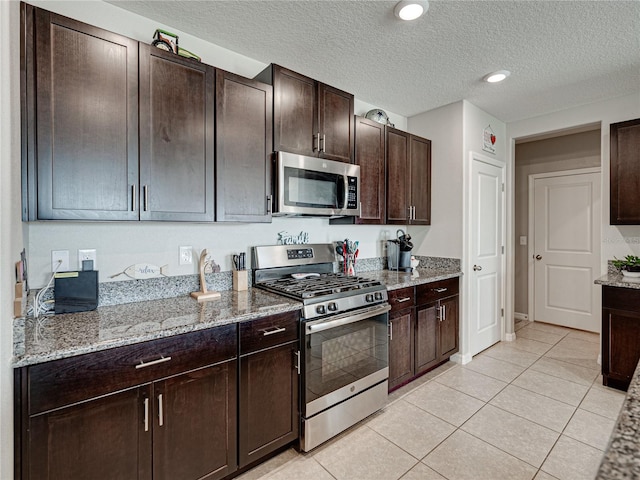 kitchen with light stone counters, light tile patterned floors, and appliances with stainless steel finishes