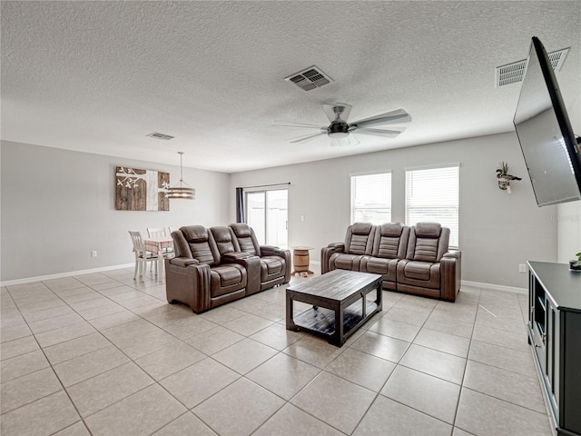 tiled living room featuring ceiling fan and a textured ceiling