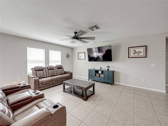 living room featuring a textured ceiling, ceiling fan, and light tile patterned floors