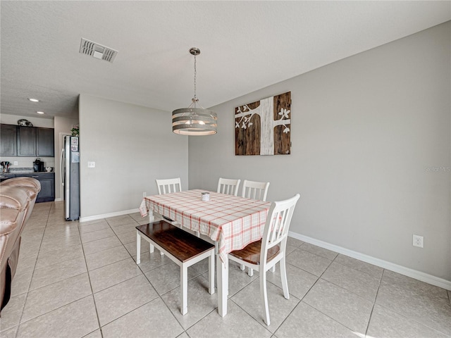 tiled dining area with a textured ceiling