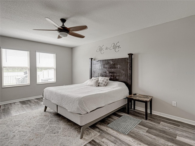 bedroom with a textured ceiling, hardwood / wood-style flooring, and ceiling fan