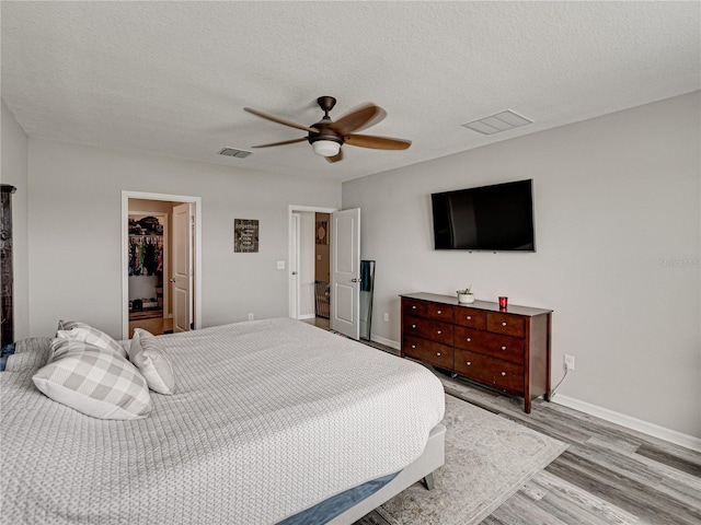 bedroom featuring ceiling fan, a textured ceiling, and light hardwood / wood-style flooring