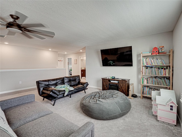 living room featuring a textured ceiling, carpet flooring, and ceiling fan