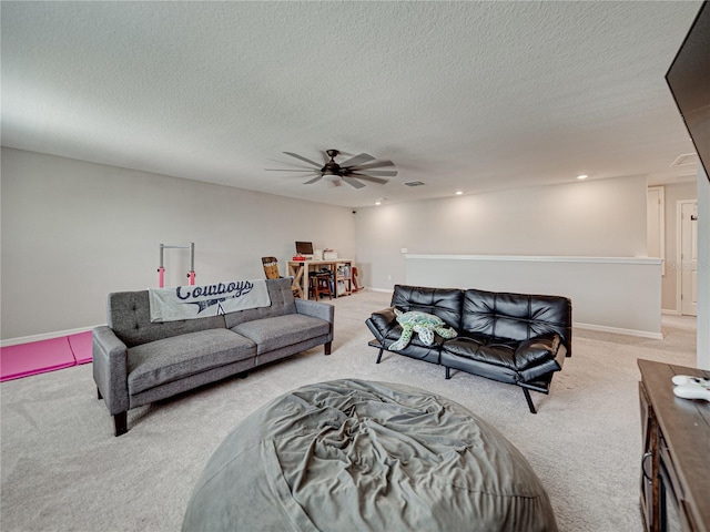 living room with ceiling fan, light carpet, and a textured ceiling