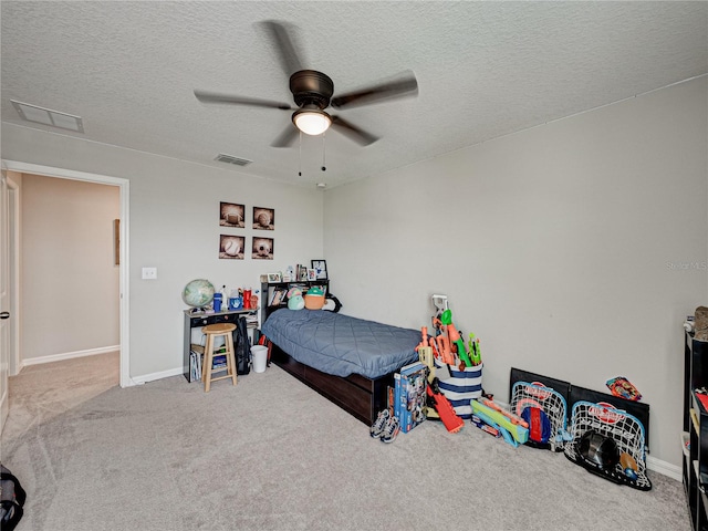 bedroom with a textured ceiling, carpet flooring, and ceiling fan