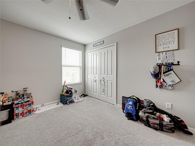 rec room featuring a textured ceiling and light colored carpet