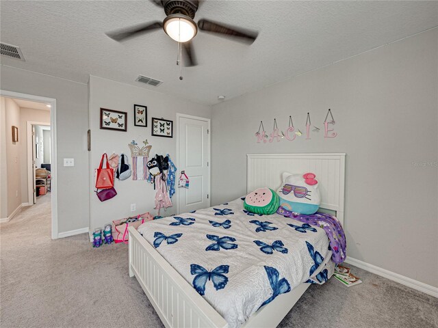 bedroom with light carpet, a textured ceiling, and ceiling fan