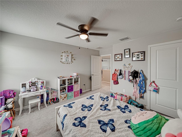 carpeted bedroom with a textured ceiling and ceiling fan