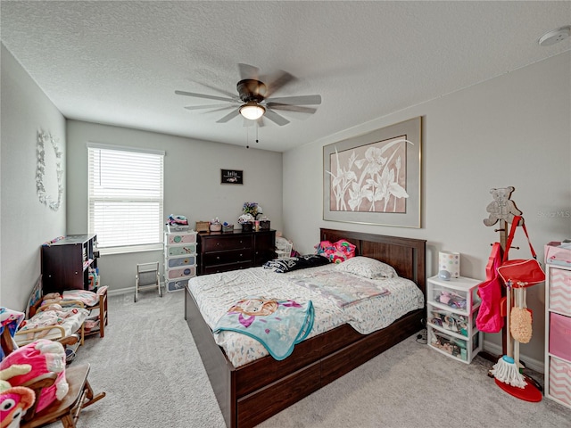 carpeted bedroom featuring ceiling fan and a textured ceiling