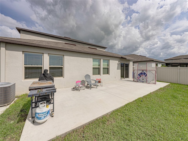 back of property featuring a lawn, a patio, and central AC unit