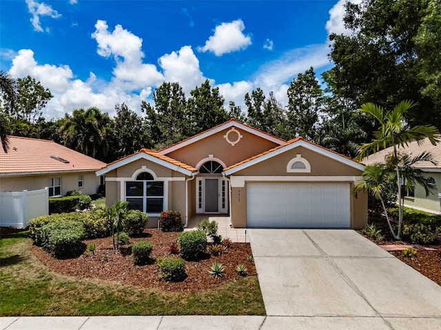 view of front of house with an attached garage, fence, driveway, and stucco siding