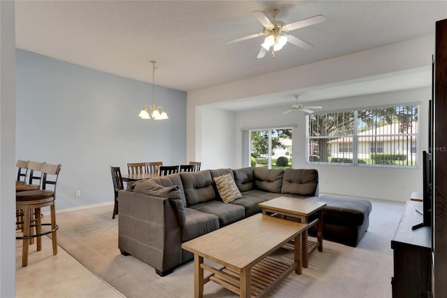 carpeted living room with ceiling fan with notable chandelier and a textured ceiling