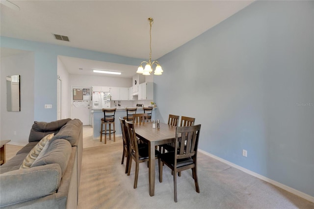 carpeted dining space featuring a chandelier