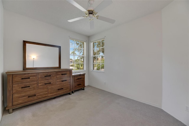 carpeted bedroom featuring ceiling fan and a textured ceiling