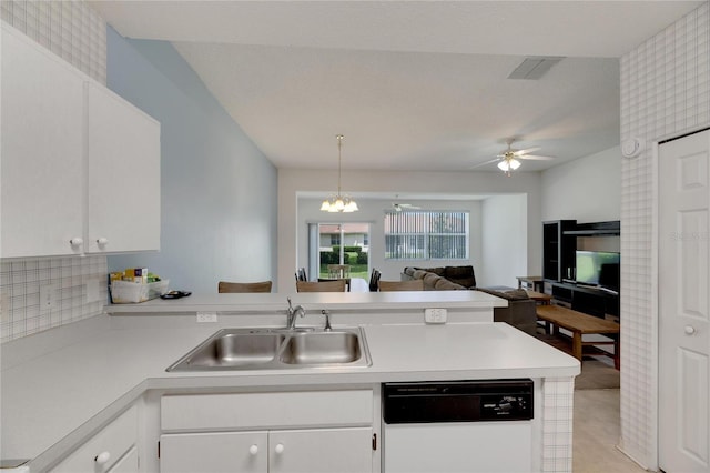 kitchen with white dishwasher, ceiling fan with notable chandelier, white cabinetry, sink, and tasteful backsplash