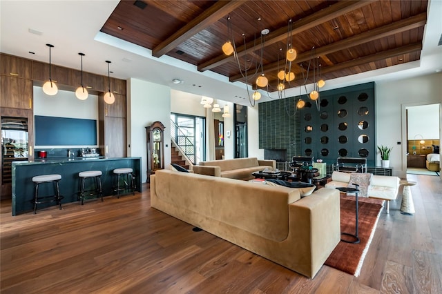 living room featuring dark wood-type flooring, a notable chandelier, beamed ceiling, and wooden ceiling