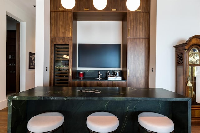 kitchen with hardwood / wood-style flooring, a kitchen bar, and a kitchen island