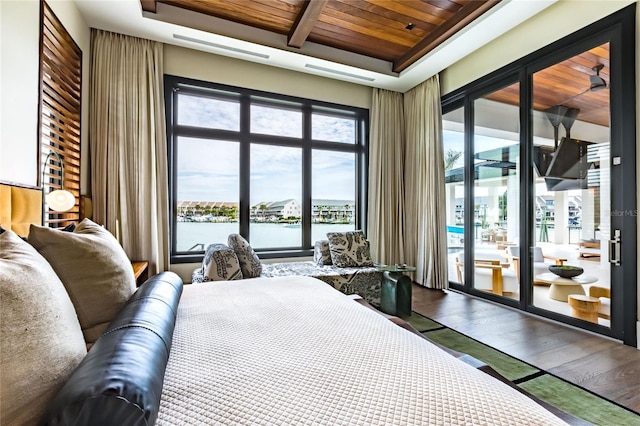 bedroom featuring wood ceiling, hardwood / wood-style floors, a water view, and access to outside