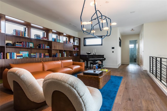 living room featuring hardwood / wood-style flooring, an inviting chandelier, and a wealth of natural light