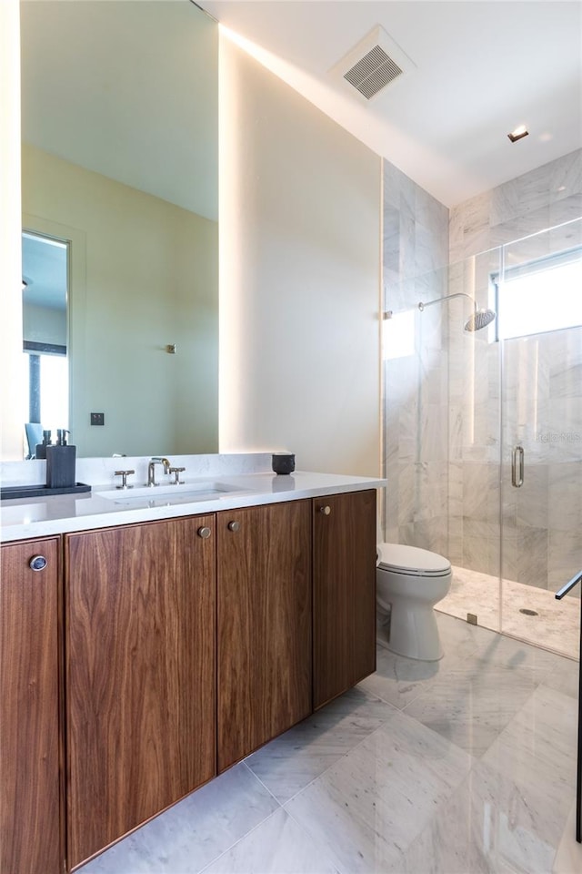 bathroom featuring toilet, a shower with door, and vanity