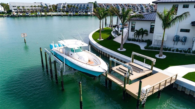 view of dock with a yard and a water view