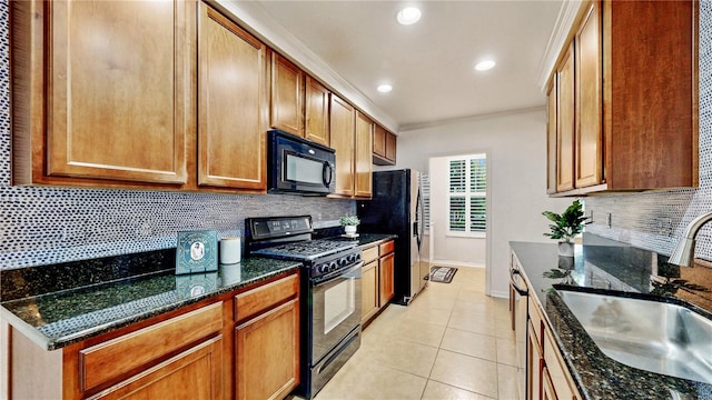 kitchen with black appliances, dark stone countertops, sink, and tasteful backsplash