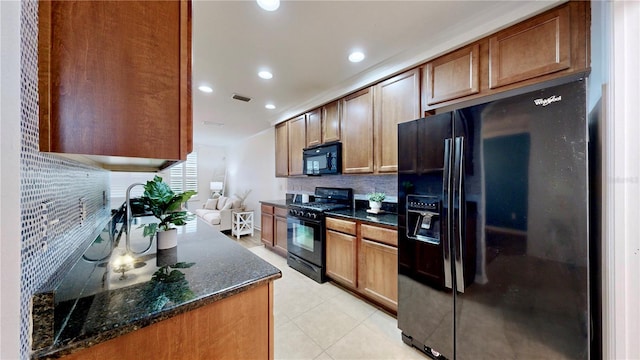 kitchen featuring black appliances, backsplash, and dark stone counters