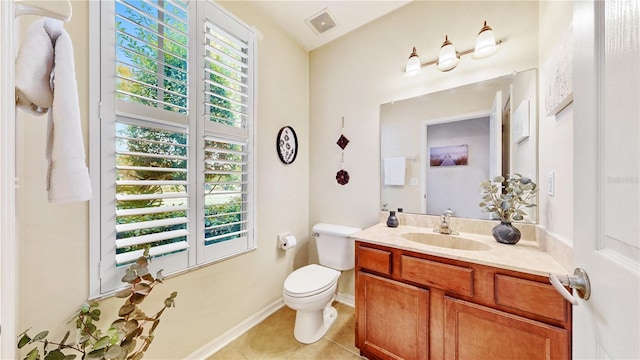 bathroom with plenty of natural light, vanity, toilet, and tile patterned flooring