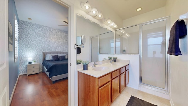 bathroom with a shower with shower door, ceiling fan, vanity, and hardwood / wood-style flooring