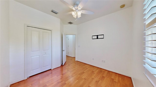 unfurnished bedroom with ceiling fan, a closet, and light wood-type flooring